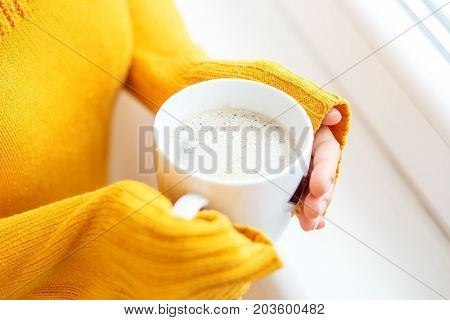 The cup of hot coffee with milk in your hands. Beverage concept lifestyle autumn and winter.