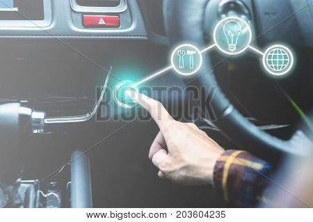 finger pressing the start/stop engine button on car with business icons for startup concept.