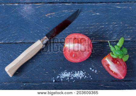 Knife With A Wooden Handle And A Black Blade. Sliced Tomatoes.