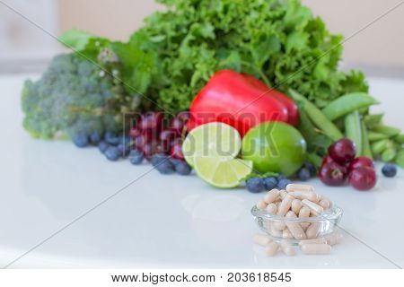Vitamins supplements in bottle on marble table.