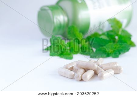 Vitamins Supplements Or Herbal In Bottle On White Table.