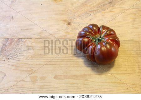 Single purple heirloom tomato aligned right, horizontal aspect
