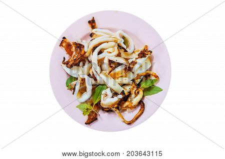 Grilled Squid with Salt and basil from top-view Thai food. Squid tentacles and garlic saute on dish isolated on white background.