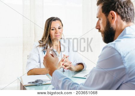 Female doctor is supervising a male patient while is using an aerosol inhaler at her office