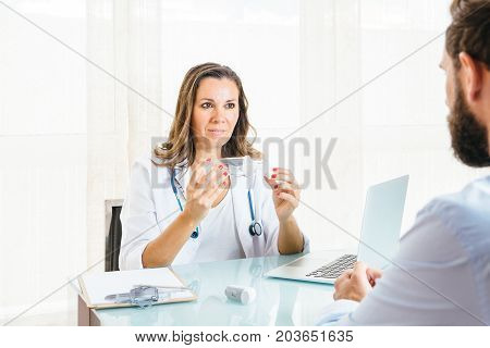 Female doctor holding a space chamber showing to a patient at her office