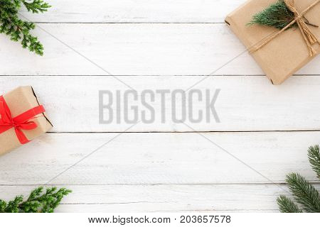 Christmas and New Year background. Christmas present gift boxes and fir leaves decoration rustic elements on white wood background. Creative flat lay top view design