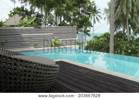 Wicker furniture edge the terrace pool for relaxation.