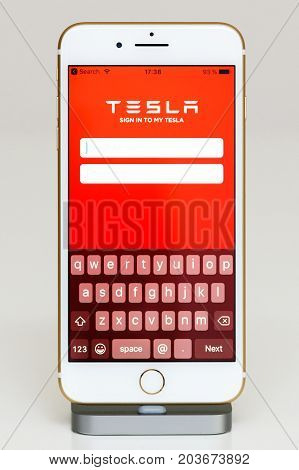 PARIS FRANCE - SEP 26 2016: New Apple iPhone 7 Plus in docking station after unboxing and testing by installing and running the app application software Tesla Sign in to my tesla app