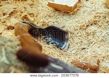 Rusty tip of sharp ax lies on edging boards