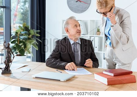 mature lawyers working with contract together in office