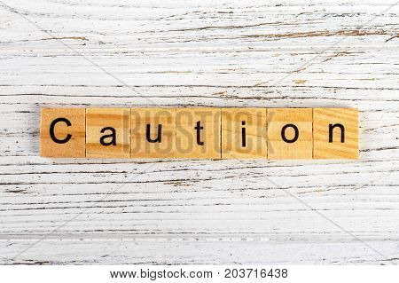 CAUTION word made with wooden blocks concept