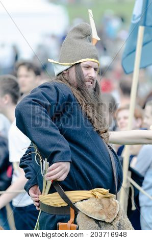 MOSCOW, RUSSIA-August 28, 2016: Male medieval archer in costume of ancient troop is aiming with arrow and curve at a target.