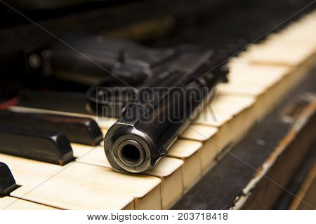 Dlack Gun On The Keys Of Piano Close Up