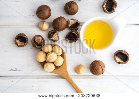 The Macadamia Nut Oil and peeled macadamia nut on white table ﻿use for Healthy Skin and Hair and Natural Healing Oil Treatment overhead and top view