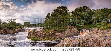 The River Tees cascades over the Whin Sill at Low Force Waterfall as the Pennine Way follows the southern riverbank