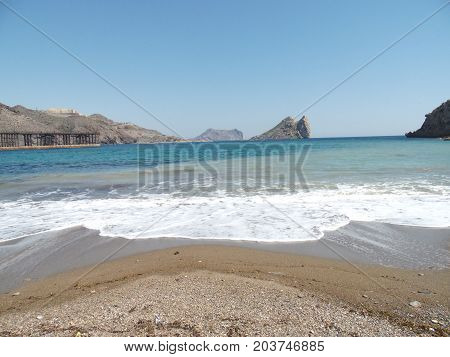 playa de arena blanca con olas e isla
