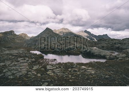 High Altitude Rocky Landscape And Little Lake. Majestic Alpine Landscape With Dramatic Stormy Sky. W