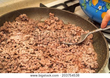 Closeup of minced meat being cooked on skillet