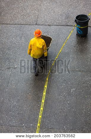 Construction Worker Pushing A Wheelbarrow On The Street