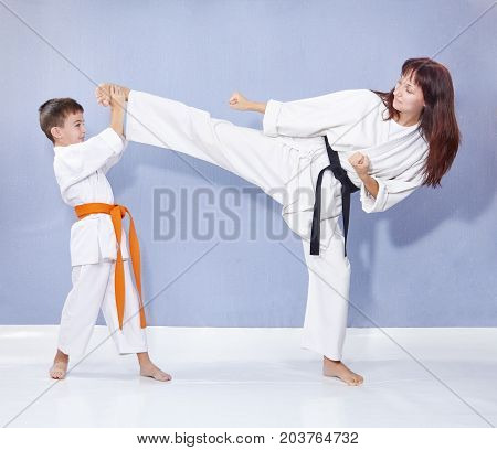 Sports family are training kick leg on the grey background
