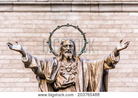 Ile D'Orleans Canada - June 1 2017: Saint-Jean church parish with stone architecture and Jesus Christ statue with outstretched open arms and illumination lamps