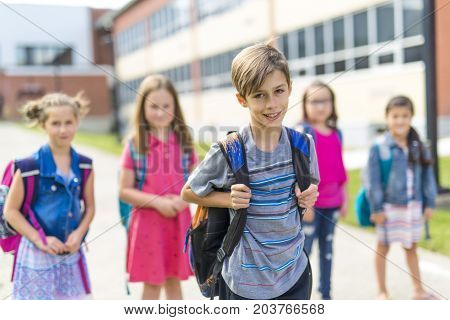 The Great Portrait Of School Pupil Outside Classroom Carrying Bags