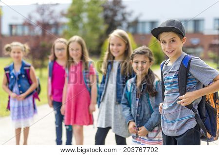 The Great Portrait Of School Pupil Outside Classroom Carrying Bags