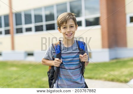 The Great Portrait Of School Pupil Outside Classroom Carrying Bags