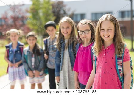 The Great Portrait Of School Pupil Outside Classroom Carrying Bags