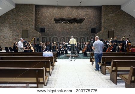 ROMEOVILLE, ILLINOIS / UNITED STATES - MAY 21, 2017: Dr. Lawrence Sisk conducts the Metropolitan Youth Symphony Orchestra (MYSO) in a dress rehearsal prior to a concert in Borromeo Hall at Lewis University.