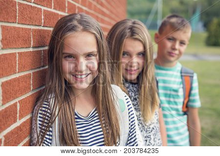 The Great Portrait Of School Pupils Outside Classroom Carrying Bags