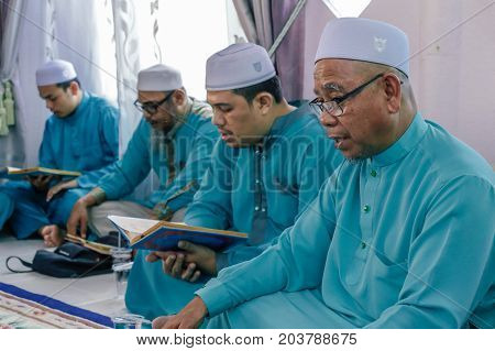 Labuan,Malaysia-Aug 30,2017:Muslim men perform Quran recitation during Aqiqah ceremony in Labuan,Malaysia.Islamic traditions after a baby is born include shaving his head & sacrificing an animal