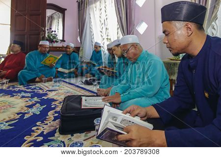 Labuan,Malaysia-Aug 30,2017:Muslim men perform Quran recitation during Aqiqah ceremony in Labuan,Malaysia.Islamic traditions after a baby is born include shaving his head & sacrificing an animal