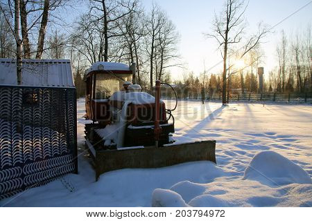 Tractor in the parking lot covered with snow