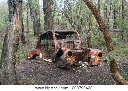 wrecked rusty rustic car in nature left behind