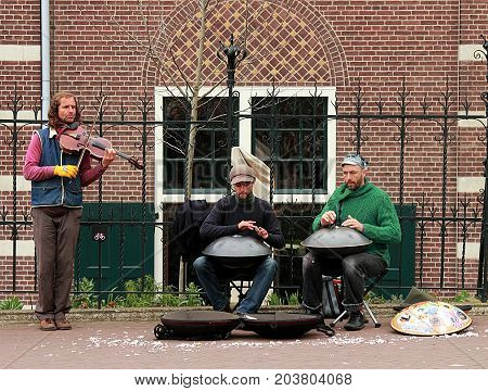 Amsterdam, Netherlands - April 5, 2016: Street musicians with hang drums and violin performing in Amsterdam, Netherland