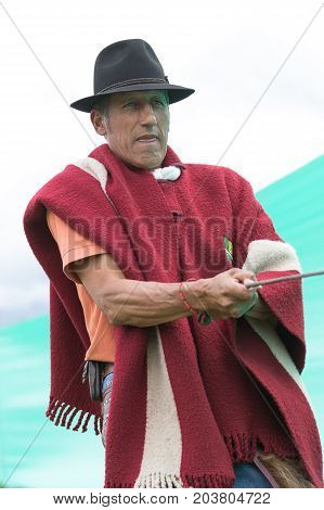June 3 2017 Machachi Ecuador: cowboy wearing traditional poncho pulling on a lasso at a rural rodeo
