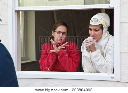 Two Women Discuss Construction Details While Standing In Window Frame For Habitat For Humanity