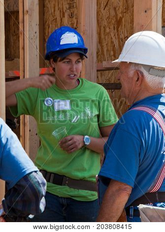 Two People Discuss Construction Plans For Habitat For Humanity
