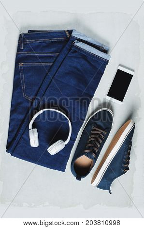 Fashionable men's clothing. Jeans and accessories on grey background