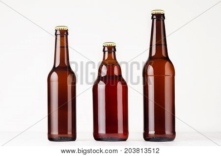Set of different brown beer bottles 500ml and 330ml mock up. Template for advertising design branding identity on white wood table.