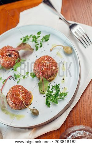 Above View Of Salmon Tartar On A Dark Wooden Background, Studio Shot