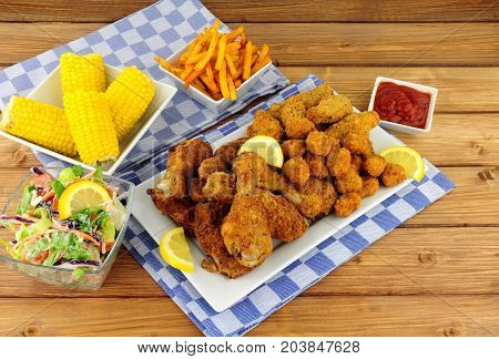Collection of Southern fried chicken products with sweetcorn and salad