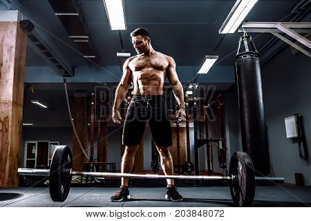 Muscular fitness man threw the bar on the floor after deadlift of a barbell in modern fitness center. Functional training. Snatch exercise