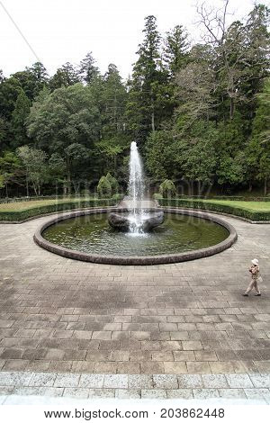 Female tourist walking around a fountain in Naritasan Temple Narita Japan 16. april 2012