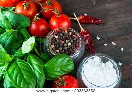 Tomatoes And Bunch Of Fresh Green Basil On A Dark Wood Background,