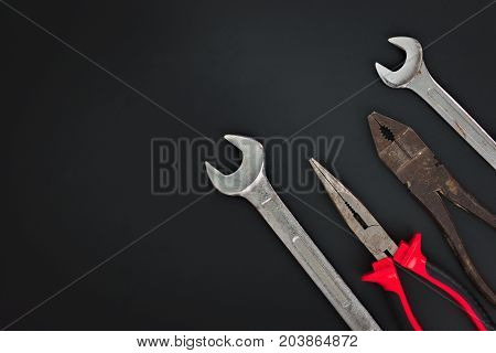 Must have at home used hand tools Combination Pliers, Needle Nose Pliers, wrench on black background with copy space