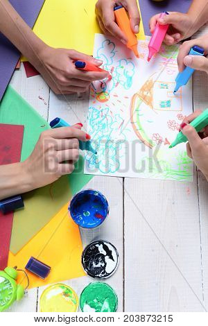 Markers In Male And Female Hands Draw On White Paper