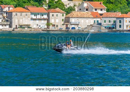 MONTENEGRO LEPETANE - June 04/2017: Father rolls his son on a fast jetski.