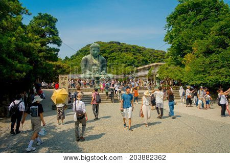 TOKYO, JAPAN JUNE 28 - 2017: Crowd of people posing and taking pictures at monumental bronze statue of the Great Buddha in Kamakura, Japan.
